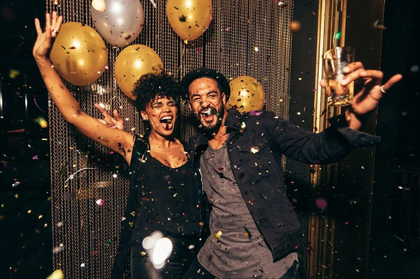 A man and woman are celebrating with balloons.